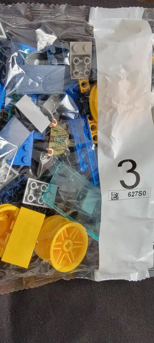 4 large yellow wheels, a windshield, a motor and a figure in an olive green shirt