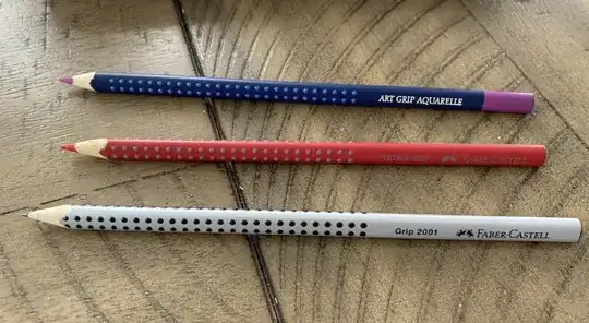 photo depicting the Art Grip Aquarelle, Colour Grip, and Grip 2001 pencils lying on a wooden surface