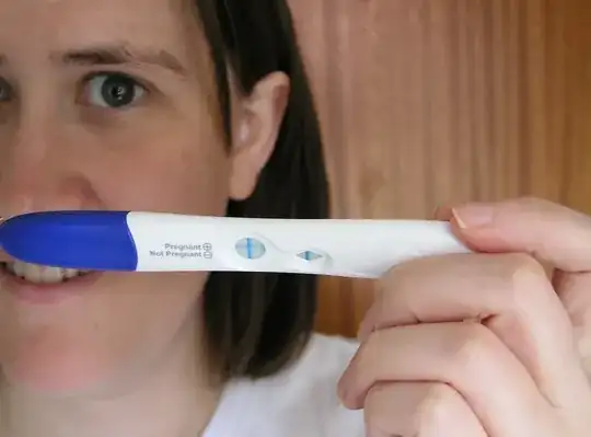 Woman holding a positive pregnancy test