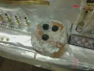 A jelly donut with glass oil-cups sunk into it