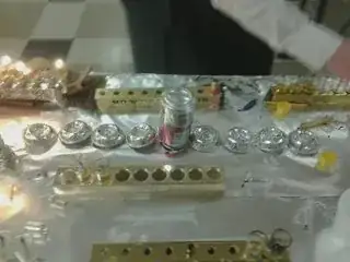 Circular foil inserts for Shabbos candlesticks, bent so that they will rest on the table, lined up