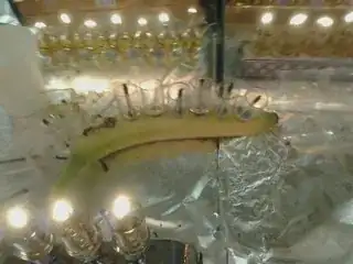 A banana with the bottoms of glass oil-cups poked into it