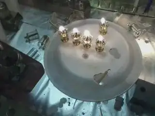 An overturned sytofoam plate with the bottoms of glass oil-cups poked into it