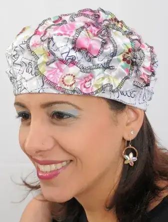 a woman with a hat on her head, with hair coming out the bottom of the hat both down the back of her head and her neck and a little at her temple