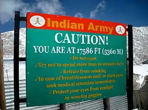 Sign displays "Caution! You are at 17586&nbsp;ft (5360&nbsp;m)"