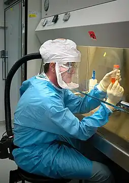 Dr. Terrence Tumpey examining a laboratory-grown reconstruction of the 1918 Spanish flu virus in a biosafety level 3 environment.