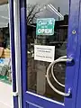 Shop door showing social distancing measures.