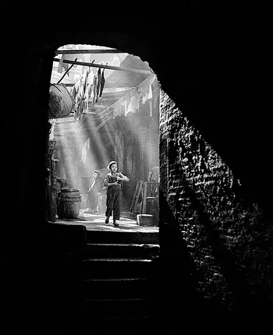 child in doorway illuminated by rays of light from above