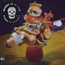 Ridiculous Bloody Mary garnished with burgers, wings, and hot dogs
