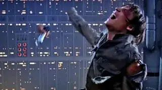 Frame from "The Empire Strikes Back;" Luke, right of frame facing left, recoils, head back, eyes shut and crying out, as his severed hand flies away still holding his lightsaber.