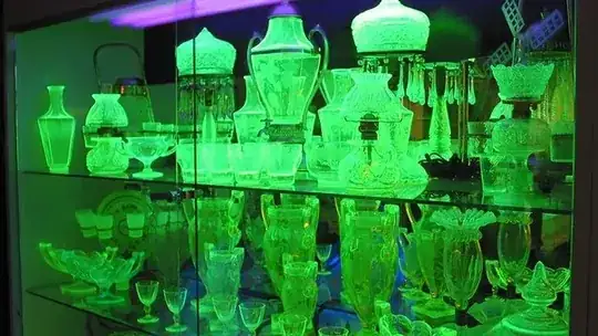 Image of uranium glass emitting a bright green light under UV illumination