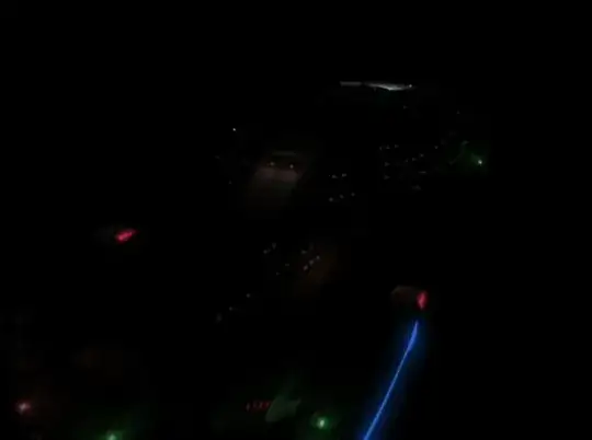 Voyager in a black starless void, viewed from above the starboard warp nacelle.  Voyager itself is almost black, except for the glow of the warp drives and light leaking from portholes.