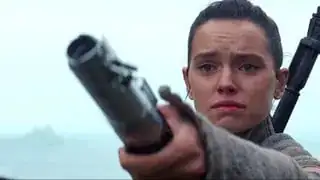 Rey holding Luke Skywalker's Lightsaber and offering it up to him.
