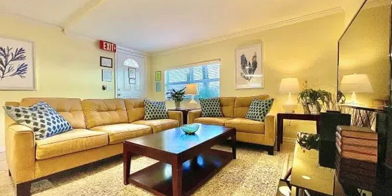 Living room showing a sectional sofa, coffee table, and a window.