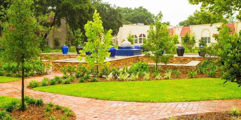  landscaped garden with a fountain, greenery, and blue decorative vases