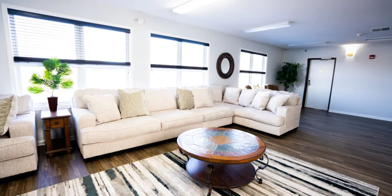 A spacious lounge with a sectional sofa and large windows.