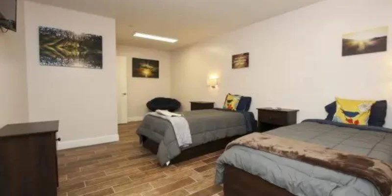 Shared bedroom with two beds and wooden floors.