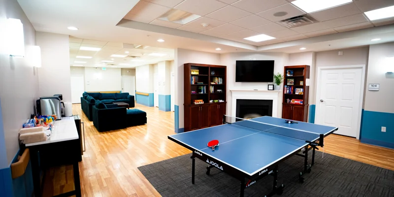  Common area with a ping pong table, bookshelves, and seating.