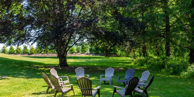 Outdoor common area with chairs arranged in a circle on the lawn.