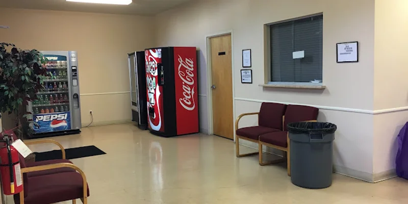 Waiting area with vending machines, chairs nesxt to reception.