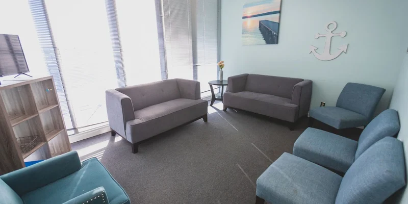 Lounge with seating and large windows.