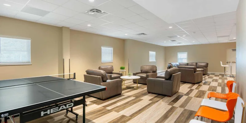 Recreation room with ping pong table and arraged couches.