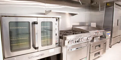 Kitchen with a large oven, stove, and refrigerators.