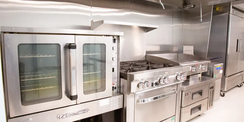 Kitchen with a large oven, stove, and refrigerators.