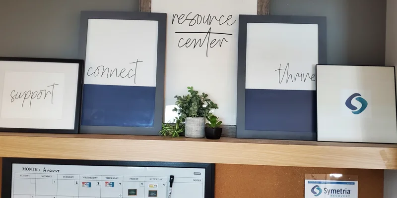 A resource center display with framed motivational words and a calendar.