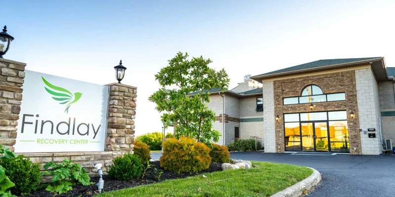 The exterior of Findlay Recovery Center with a sign and landscaping.