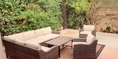 Outdoor patio with cushioned wicker seating.
