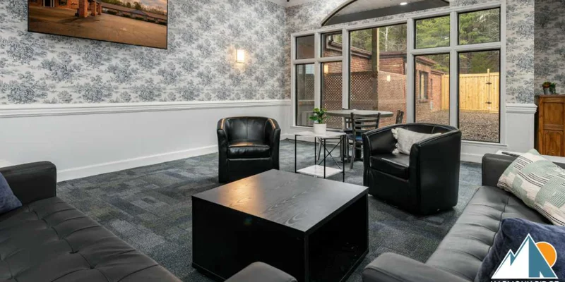 A modern lounge with black leather chairs and large windows