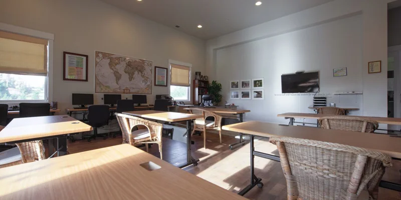 Classroom with a TV, desks and chairs.