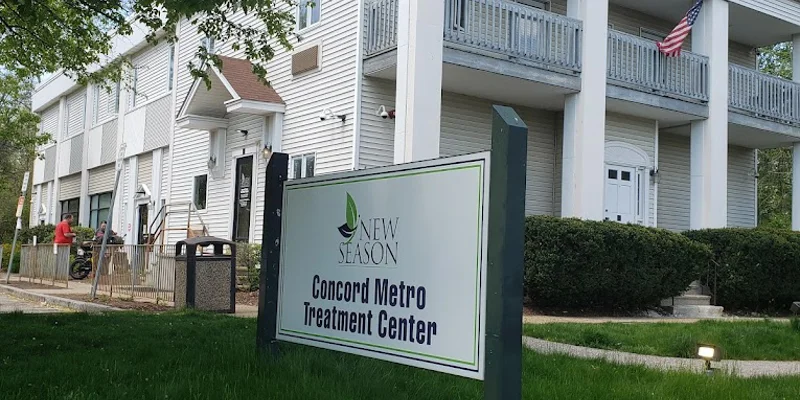 A sign for Concord Metro Treatment Center in front of a white building.