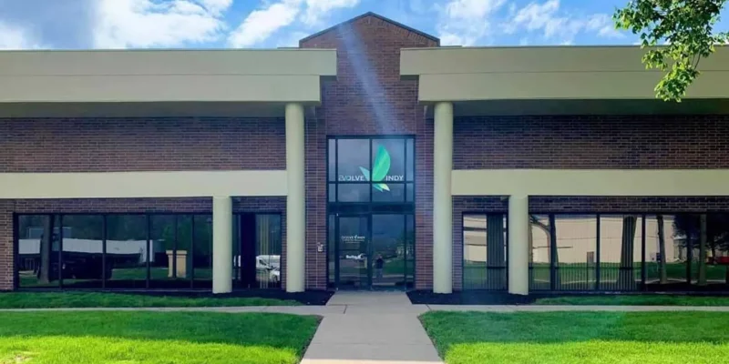 The front entrance of Evolve Indy rehab center with brick and glass design.