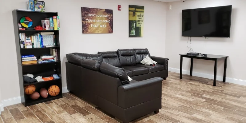  Lounge with black sectional sofa and bookshelf.