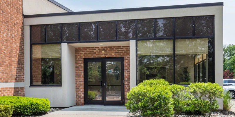 Entrance walkway with windows and a brick facade.