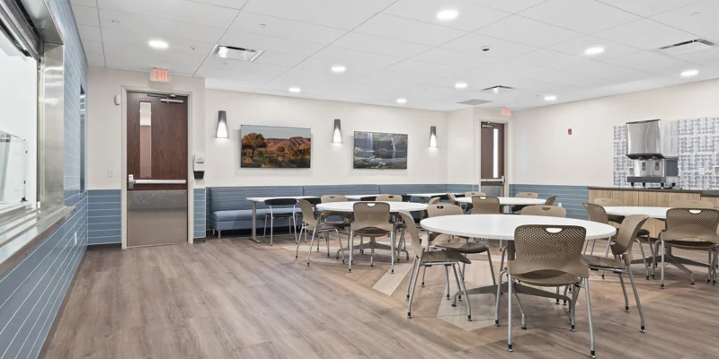 A clean, modern dining area with tables and chairs.