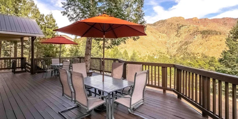 Deck with outdoor dining tables, umbrellas and seats.
