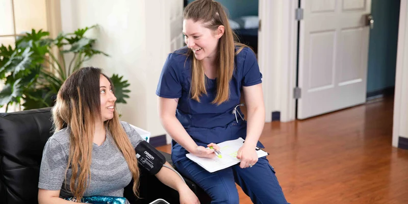 Nurse checks blood pressure of patient.