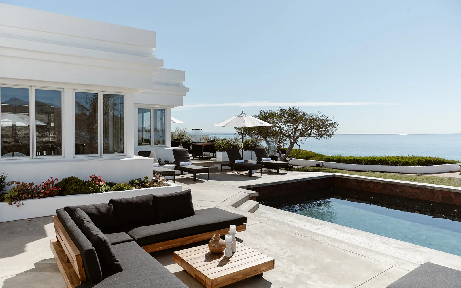  Oceanfront patio with lounge seating, umbrellas, and a private pool.