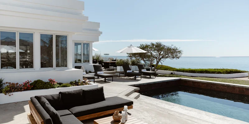  Oceanfront patio with lounge seating, umbrellas, and a private pool.