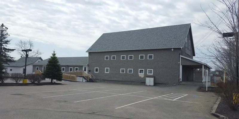 Facility exterior with accessible parking and walkway to entrance.