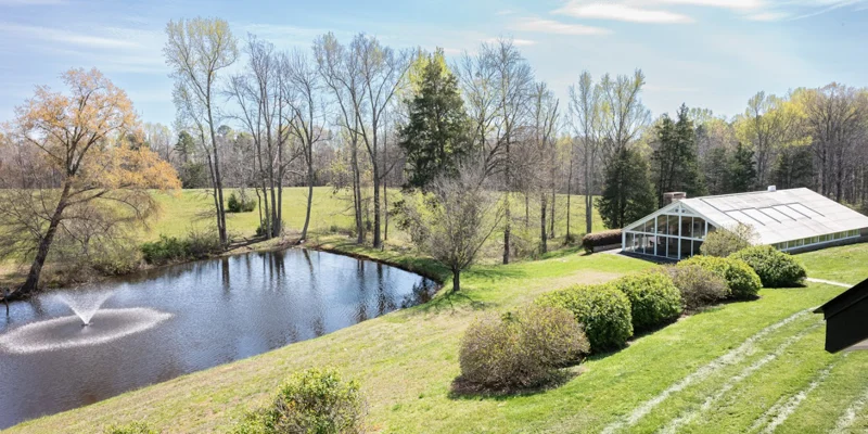 Facility exterior with pond and greenery.