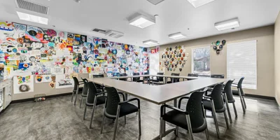 A rehab therapy room with tables and colorful wall art.