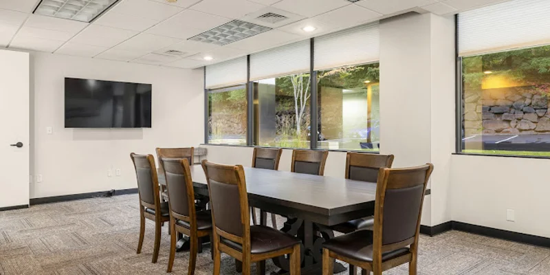 Conference room with a table, chairs and a TV.