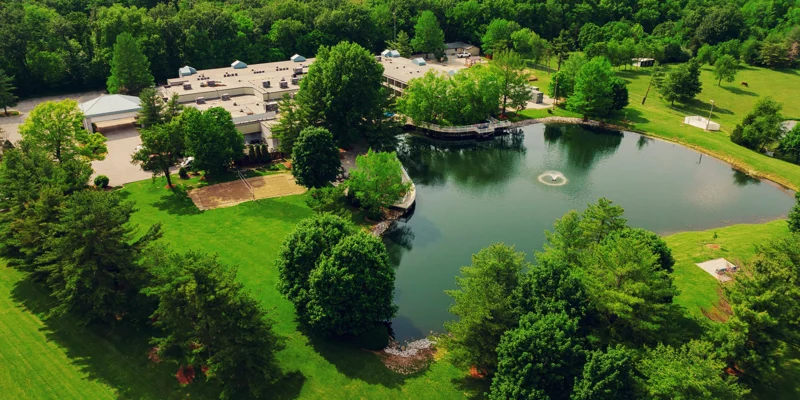 Aerial view of facility with a pond and fountain.
