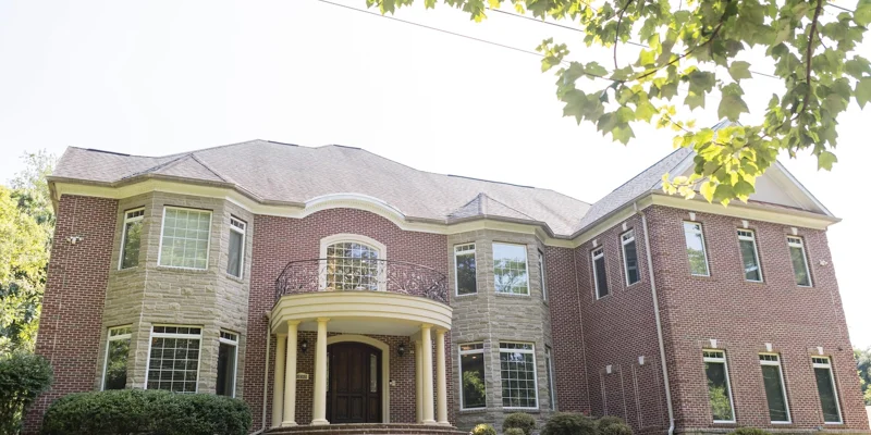 A large brick and stone rehab facility with a grand entrance and balcony
