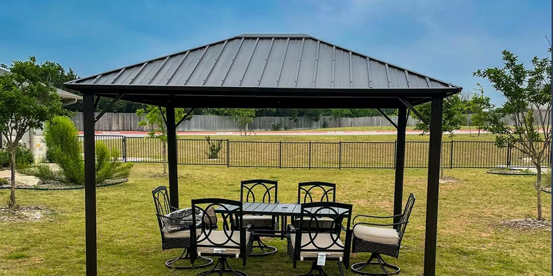 Outdoor seating area under a metal pergola.