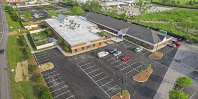 Aerial view of a large rehab facility with a parking lot.
